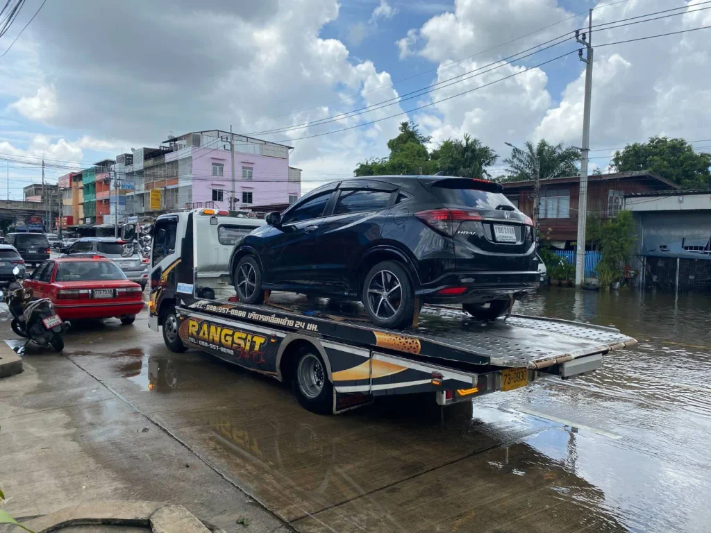 ทีมงานรังสิตรถสไลด์กำลังเคลื่อนย้ายรถเสียขึ้นถาดรถสไลด์อย่างปลอดภัย แก้ปัญหาจราจรและเหตุฉุกเฉินรวดเร็วด้วยบริการ รถสไลด์ ดอนเมือง